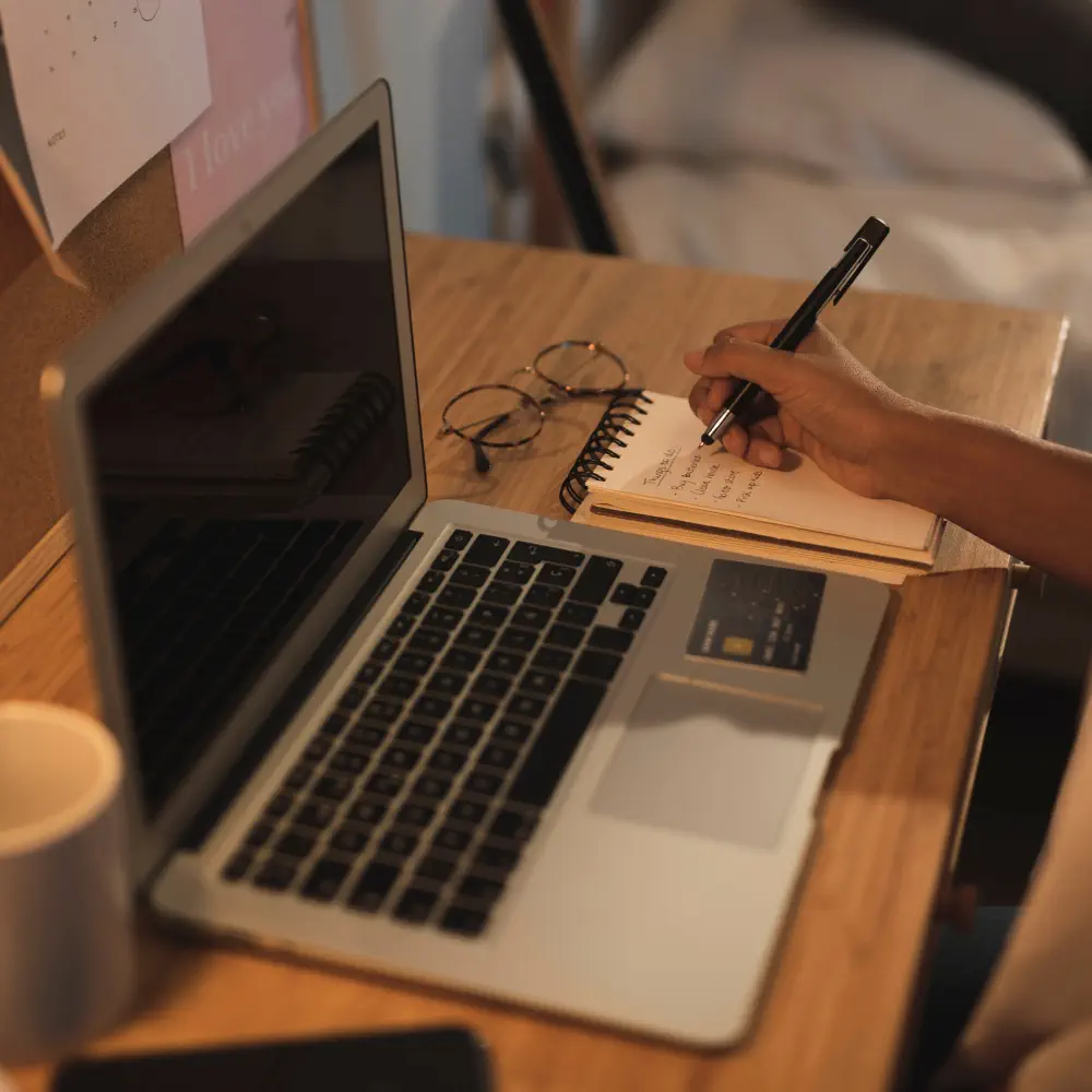 Notebook mit schreibender Hand
