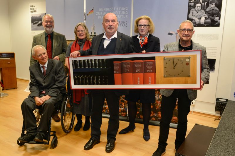 Mehrere Menschen mit einem großen gerahmten Foto