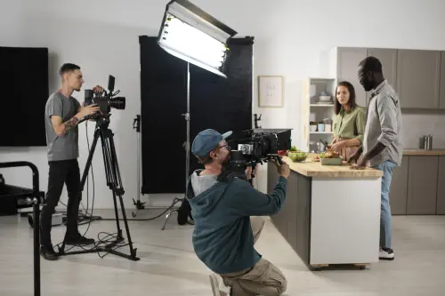 Arbeit am Filmset, Beleuchter, Kameramann und zwei Schauspieler