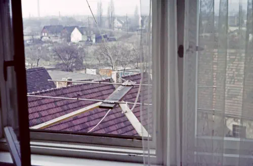 Blick aus einem Fenster, vor dem eine Antenne hängt